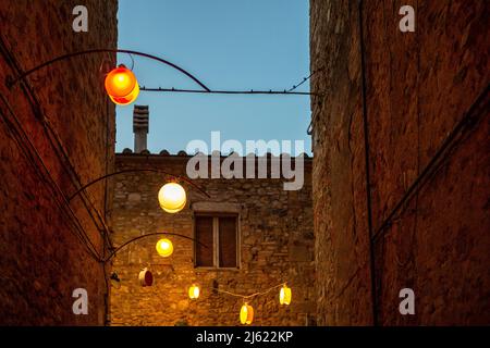 Italien, Provinz Siena, Radicondoli, Lanterns beleuchtete Altstadtallee Stockfoto