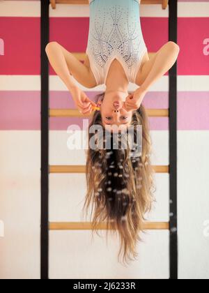 Mädchen blasen Blasen hängen kopfüber an den Wandstangen Stockfoto