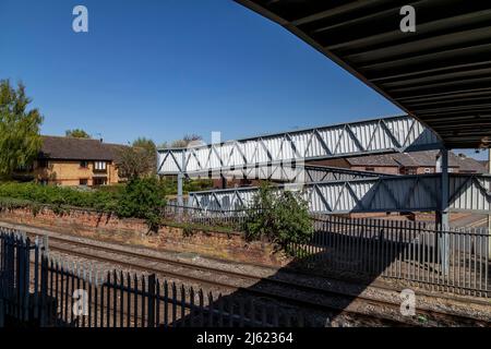 Öffentlicher Metallsteg über den Bahnlinien in Oakham, Rutland, Leicestershire, England, Großbritannien. Stockfoto