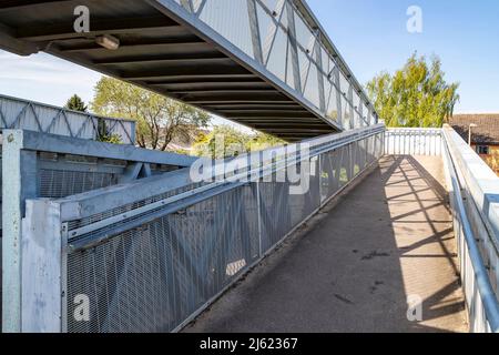 Öffentlicher Metallsteg über den Bahnlinien in Oakham, Rutland, Leicestershire, England, Großbritannien. Stockfoto