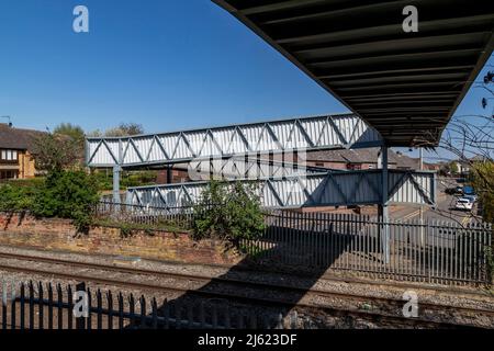 Öffentlicher Metallsteg über den Bahnlinien in Oakham, Rutland, Leicestershire, England, Großbritannien. Stockfoto