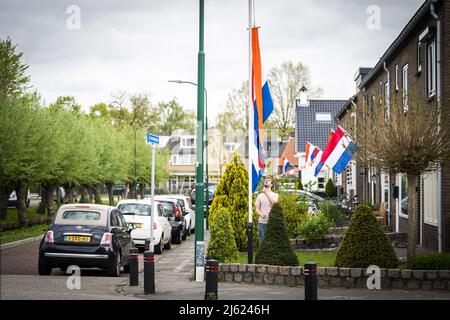 2022-04-27 11:00:38 BUNSCHOTEN-SPAKENBURG - Flaggen in den Straßen von Bunschoten-Spakenburg. Nach zwei Jahren, in denen der Königstag aufgrund der Coronapandemie in kleinem Umfang gefeiert werden musste, ist dieses Jahr ein Tag voller alter Traditionen, mit dekorierten Häusern, alten holländischen Spielen und einem Kleidermarkt. ANP JEROEN JUMELET niederlande Out - belgien Out Stockfoto