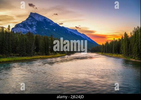 Sonnenaufgang über dem Bow River und Mount Rundle von der Banff Fußgängerbrücke in Kanada Stockfoto