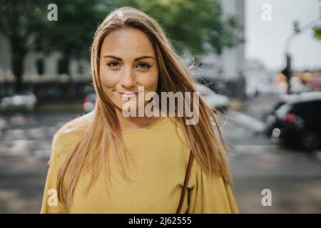 Lächelnde Frau, die auf der Straße steht Stockfoto