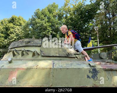 Kind spielt auf einer militärischen Anlage im Park Stockfoto