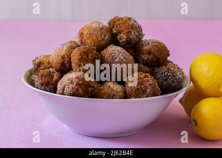 Die flauschigen Pfannkuchen mit Zitrone auf einem rosa Hintergrund. Stockfoto