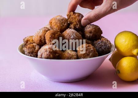 Die flauschigen Pfannkuchen mit Zitrone auf einem rosa Hintergrund. Stockfoto