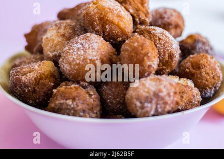 Die flauschigen Pfannkuchen mit Zitrone auf einem rosa Hintergrund. Stockfoto