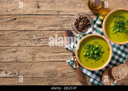 Grüne Erbsensuppe in einer Schüssel auf rustikalem Holztisch Stockfoto