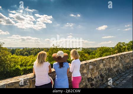 Drei Frauen sitzen auf der Steinmauer und genießen das Land Stockfoto