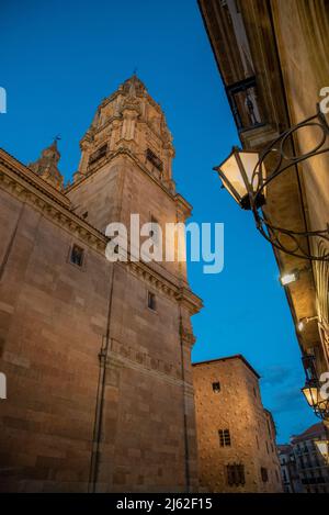 Blick auf den Turm der 'Clerecia' und im Hintergrund die 'casa de las conchas' (Haus der Muscheln) in der blauen Stunde, Salamanca, Spanien. Stockfoto