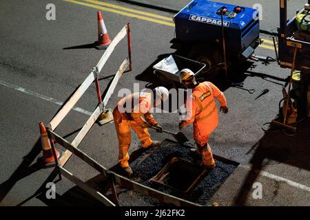 Nächtliche Straßenarbeiten, bei der eine kaputte Schachtabdeckung auf der Straße repariert wurde, in Hertfordshire, Großbritannien. Von den Auftragnehmern Cappagh im Auftrag von Thames Water durchgeführte Arbeiten. Foto: David Levenson/Alamy Stockfoto