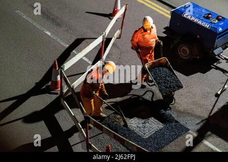 Nächtliche Straßenarbeiten, bei der eine kaputte Schachtabdeckung auf der Straße repariert wurde, in Hertfordshire, Großbritannien. Von den Auftragnehmern Cappagh im Auftrag von Thames Water durchgeführte Arbeiten. Foto: David Levenson/Alamy Stockfoto