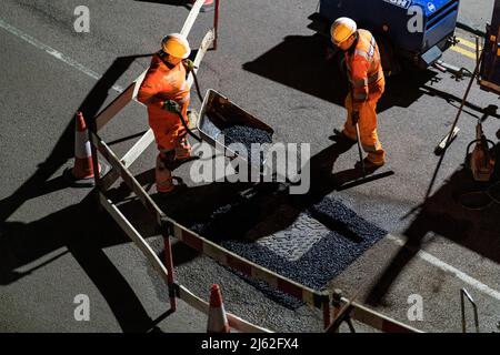 Nächtliche Straßenarbeiten, bei der eine kaputte Schachtabdeckung auf der Straße repariert wurde, in Hertfordshire, Großbritannien. Von den Auftragnehmern Cappagh im Auftrag von Thames Water durchgeführte Arbeiten. Foto: David Levenson/Alamy Stockfoto