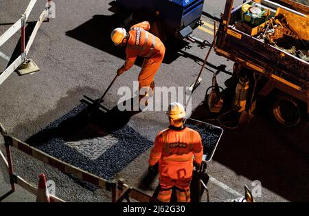 Nächtliche Straßenarbeiten, bei der eine kaputte Schachtabdeckung auf der Straße repariert wurde, in Hertfordshire, Großbritannien. Von den Auftragnehmern Cappagh im Auftrag von Thames Water durchgeführte Arbeiten. Foto: David Levenson/Alamy Stockfoto