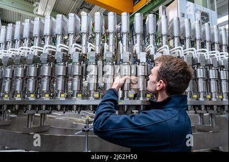 Neutraubling, Deutschland. 25. April 2022. Ein Mitarbeiter der Krones AG arbeitet an einer Abfüllanlage in der Produktion. Quelle: Armin Weigel/dpa/Alamy Live News Stockfoto