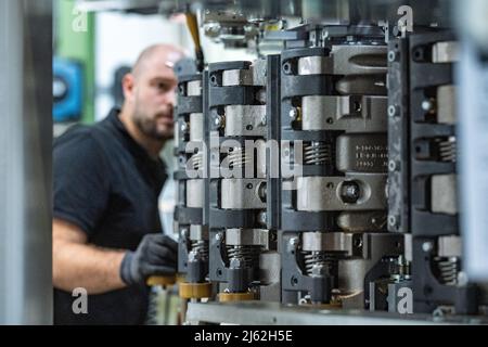 Neutraubling, Deutschland. 25. April 2022. Ein Mitarbeiter der Krones AG arbeitet in der Produktion an einer Streckblasmaschine. Quelle: Armin Weigel/dpa/Alamy Live News Stockfoto