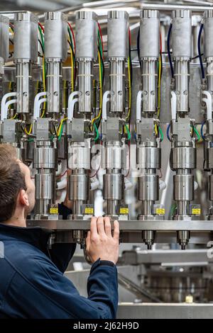 Neutraubling, Deutschland. 25. April 2022. Ein Mitarbeiter der Krones AG arbeitet an einer Abfüllanlage in der Produktion. Quelle: Armin Weigel/dpa/Alamy Live News Stockfoto