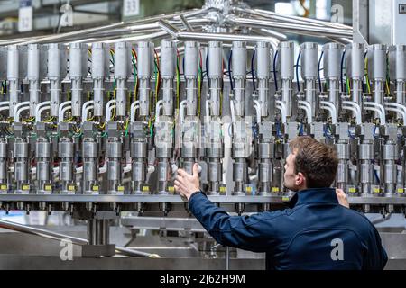 Neutraubling, Deutschland. 25. April 2022. Ein Mitarbeiter der Krones AG arbeitet an einer Abfüllanlage in der Produktion. Quelle: Armin Weigel/dpa/Alamy Live News Stockfoto