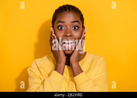 Portrait von attraktiven fröhlich erstaunt Brünette Mädchen plötzliche Nachrichten Reaktion isoliert über hellen gelben Hintergrund Stockfoto