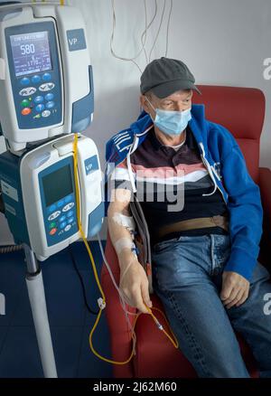 Mann, der für eine Chemotherapie im Zimmer sitzt, Stockfoto