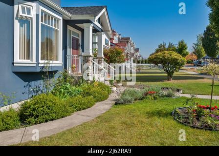 Vorgarten von Familienhäusern entlang der Straße an sonnigen Tag Stockfoto