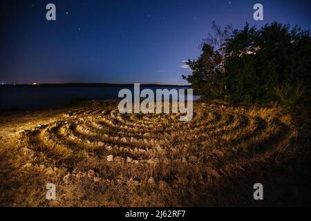 Spirallabyrinth aus Steinen an der Küste, Luftaufnahme. Stockfoto