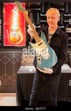 VEREINIGTES KÖNIGREICH. 27. April 2022. Martin Nolan, Executive Director von Julian's Auction, stellt Kurt Cobains ikonisches Musikvideo „Smells Like Teen Spirit“ von 1969 Fender Mustang mit einer Anfangsschätzung von $600.000 bis $800.000 und anderen Musik-Memorabilien am 27. April 2022 im Hard Rock Cafe in Piccadilly in London vor. Die Auktion findet im Rahmen einer dreitägigen Veranstaltung statt, die zwischen dem 20. Und 22. Mai 2022 im New Yorker Time Square Hard Rock Cafe stattfindet. (Foto: Claire Doherty/Sipa USA) Quelle: SIPA USA/Alamy Live News Stockfoto