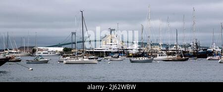 Newport, Rhode Island, USA - 2. Juli 2021: Newport-Hafen mit vielen festfahrenden Segelbooten und Yachten mit der newport-Brücke im Hintergrund auf einer wolkenbewb Stockfoto