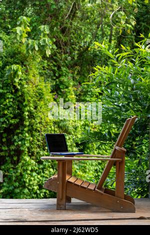 Ein Laptop auf einem Adirondack-Stuhl in einer Regenwald-Lodge, digitales Nomadenkonzept, Provinz Chiriqui, Panama, Mittelamerika Stockfoto