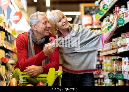 Glückliche Kunden Seniorenpaar, das im Supermarkt Lebensmittel kauft Stockfoto