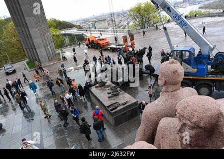 Ukraine. Kiew, 26. April 2022, Arbeiter demontieren das sowjetische Gewerkschaftsdenkmal, das die ukrainisch-russische Freundschaft symbolisiert, weil Russland weiterhin in die Ukraine einmarschiert. Am 25. April 2022 kündigte der Bürgermeister von Kiew, Vitali Klitschko, die Entfernung des sowjetischen Unionsdenkmals in Zentral-Kiew an. Dieses Denkmal wurde 1982 als Symbol der Wiedervereinigung der Ukraine und Russlands während der Sowjetzeit errichtet. Die Statue von zwei Männern mit einer Medaille stellt den Orden der Freundschaft der Völker der Sowjetunion dar, während der regenbogenartige Bogen den Namen „Volksfreundschaftsbogen“ nennt. Außerdem einige Straßen li Stockfoto