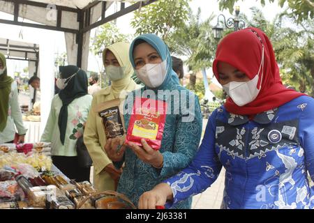 Madiun, Ost-Java, Indonesien. 27. April 2022. Leiter des Madiun Regency Family Welfare Empowerment Team (TP PKK) Penta Lianawati Ahmad Dawami mit Madiun Branch Bhayangkari Chair Hanna Anton Prasetyo und ihren jeweiligen Führungsreihen beim Einkauf lokal verarbeiteter Lebensmittel- und Getränkeprodukte für Regency Micro, Kleine und mittlere Unternehmen (MSMEs) Madiun auf dem Basar Ramadhan 1443 Hijriyah/Th 2022, der im Madiun Regency Government Center abgehalten wurde (Foto: © Ajun Ally/Pacific Press via ZUMA Press Wire) Stockfoto