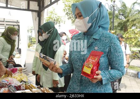 Madiun, Ost-Java, Indonesien. 27. April 2022. Leiter des Madiun Regency Family Welfare Empowerment Team (TP PKK) Penta Lianawati Ahmad Dawami mit Madiun Branch Bhayangkari Chair Hanna Anton Prasetyo und ihren jeweiligen Führungsreihen beim Einkauf lokal verarbeiteter Lebensmittel- und Getränkeprodukte für Regency Micro, Kleine und mittlere Unternehmen (MSMEs) Madiun auf dem Basar Ramadhan 1443 Hijriyah/Th 2022, der im Madiun Regency Government Center (Puspem) stattfand (Bild: © Ajun Ally/Pacific Press via ZUMA Press Wire) Stockfoto