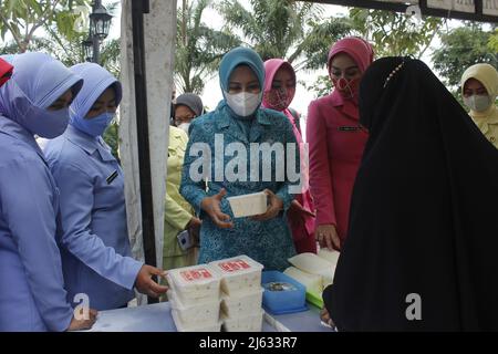 Madiun, Ost-Java, Indonesien. 27. April 2022. Leiter des Madiun Regency Family Welfare Empowerment Team (TP PKK) Penta Lianawati Ahmad Dawami mit Madiun Branch Bhayangkari Chair Hanna Anton Prasetyo und ihren jeweiligen Führungsreihen beim Einkauf lokal verarbeiteter Lebensmittel- und Getränkeprodukte für Regency Micro, Kleine und mittlere Unternehmen (MSMEs) Madiun auf dem Basar Ramadhan 1443 Hijriyah/Th 2022, der im Madiun Regency Government Center (Puspem) stattfand (Bild: © Ajun Ally/Pacific Press via ZUMA Press Wire) Stockfoto