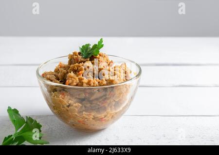 Kiopoolu, geräucherte Auberginen tauchen in eine Glasschale auf einen weißen Tisch mit Kopierfläche Stockfoto