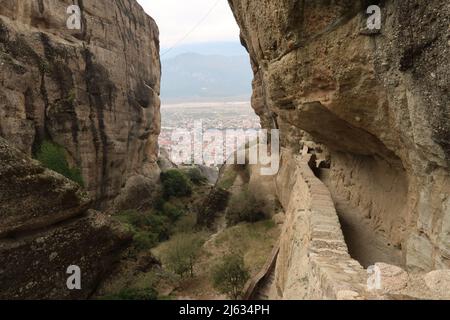 Blick auf Kalambaka zwischen den Felsen auf dem Weg zum Kloster der Heiligen Dreifaltigkeit, Meteora, Griechenland Stockfoto