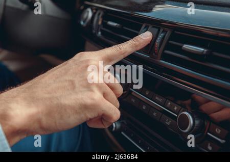 Männliche Hand drückt Knopf in seinem Auto Stockfoto
