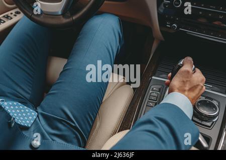 Mann, der die Hand auf das automatische Getriebe des Autos legt Stockfoto