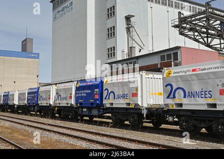 Basel, Schweiz - April 2022: Güterwaggons in Bahngleisen im Stadthafen am Rhein Stockfoto