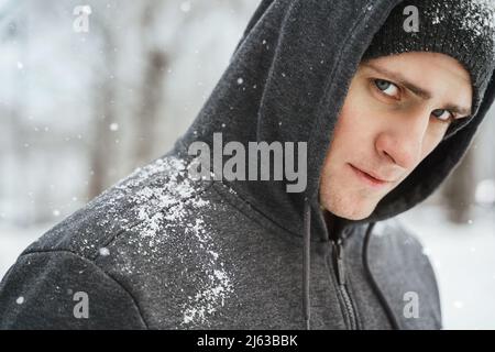 Schöner, athletischer Mann mit Hoodie während seines Wintertrainings Stockfoto