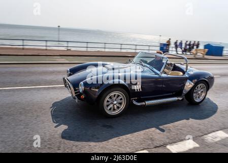 AC Cobra Auto wird am sonnigen Frühlingstag mit dem Top Down an der Strandpromenade Western Esplanade, Southend on Sea, Essex, Großbritannien, gefahren. Fahrfreuden, oben offen Stockfoto