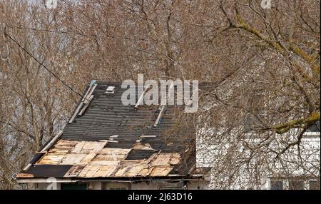 Wohndach, das dringend repariert oder ersetzt werden muss, mit fehlenden Schindeln und Rotten Wood Stockfoto