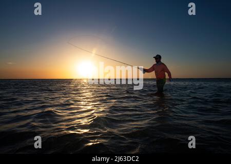 Ihr Mann Fliegenfischen bei Sonnenuntergang in der Karibik Stockfoto