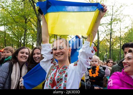 Ein junges ukrainisches Mädchen hält während des Festivals eine Nationalflagge. DAS LEBEN, DAS ICH LEBE. Das zweitägige Festival beginnt am Abend vor dem Königstag an der Königsnacht (Koninsnacht). Das Musikfestival im Freien, das den Geburtstag des Königs feiert, findet jedes Jahr am 26. Und 27. April im Stadtzentrum von Den Haag statt. Die Feier ist eine landesweite Veranstaltung. Zahlreiche Interpreten sind gleichzeitig in ganz Den Haag auf der Bühne, und der diesjährige Eröffnungsakt von 2022 ist die ukrainische Elektro-Folk-Band ‘GO A.' Die Gruppe wurde Fünfter beim letztjährigen Eurovision Song Contest 2021 in Rotterdam. Weil die drei männlichen Band m Stockfoto