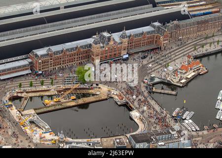 2022-04-27 12:59:39 AMSTERDAM - Luftaufnahme des Amsterdamer Hauptbahnhofs während des Königstages. Nach zwei Jahren, in denen der King's Day aufgrund der Corona-Pandemie in kleinem Umfang gefeiert werden musste, wird die Party in diesem Jahr wie gewohnt ausgelassen gefeiert. ANP BRAM VAN DE BIESES netherlands Out - belgium Out Credit: ANP/Alamy Live News Stockfoto