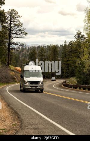 Autos fahren auf einer kurvenreichen Straße mit Haarnadelkurven in den Bergen des Bryce Canyon National Park. Stockfoto