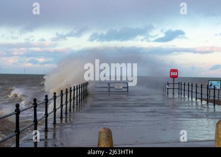 HERNE BAY: An einem kalten und stürmischen Februarabend bei Flut schlagen Wellen gegen den Hampton Pier. Stockfoto