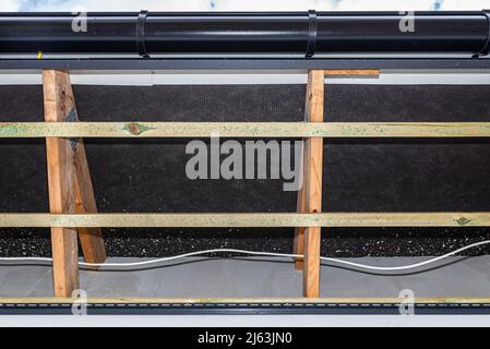 Gerüst mit drei Reihen von Holzlatten zur Befestigung der PVC-Soffit, sichtbare Kabel für die Beleuchtung. Stockfoto
