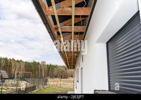 Gerüst mit drei Reihen von Holzlatten zur Befestigung der PVC-Soffit, sichtbare Kabel für die Beleuchtung. Stockfoto